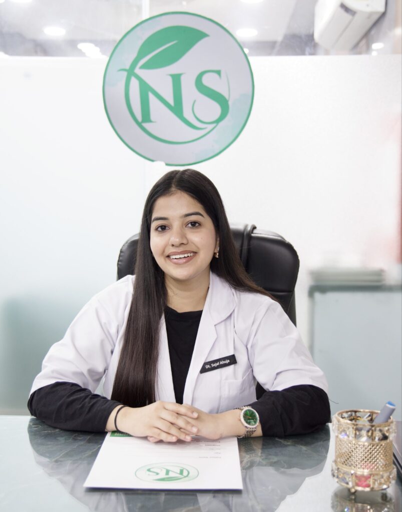 Dt. Sejal Ahuja in a white clinical coat, seated at her consultation desk at the Nutritics by Sejal clinic in South Delhi